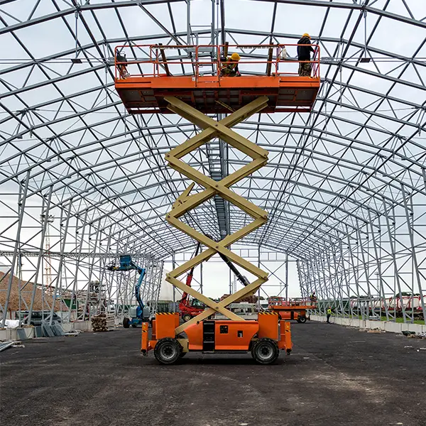 Scissor lift being used at a UK construction site for steel erection and maintenance tasks.